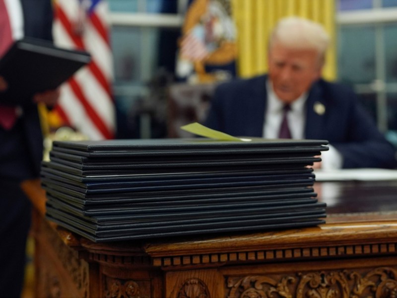 President Donald Trump signs executive orders in the Oval Office of the White House.